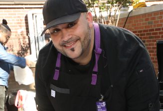 A male non-clinical professional staff member smiles as he does his work.