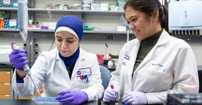 Two female research staff members work together in a laboratory setting.