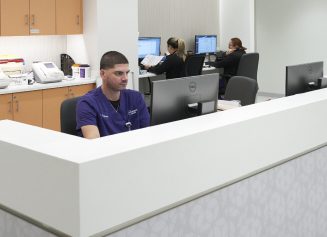 A workstation at an NYU Langone outpatient facility with several staff members working on their computers.