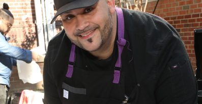 A male non-clinical professional staff member smiles as he does his work.