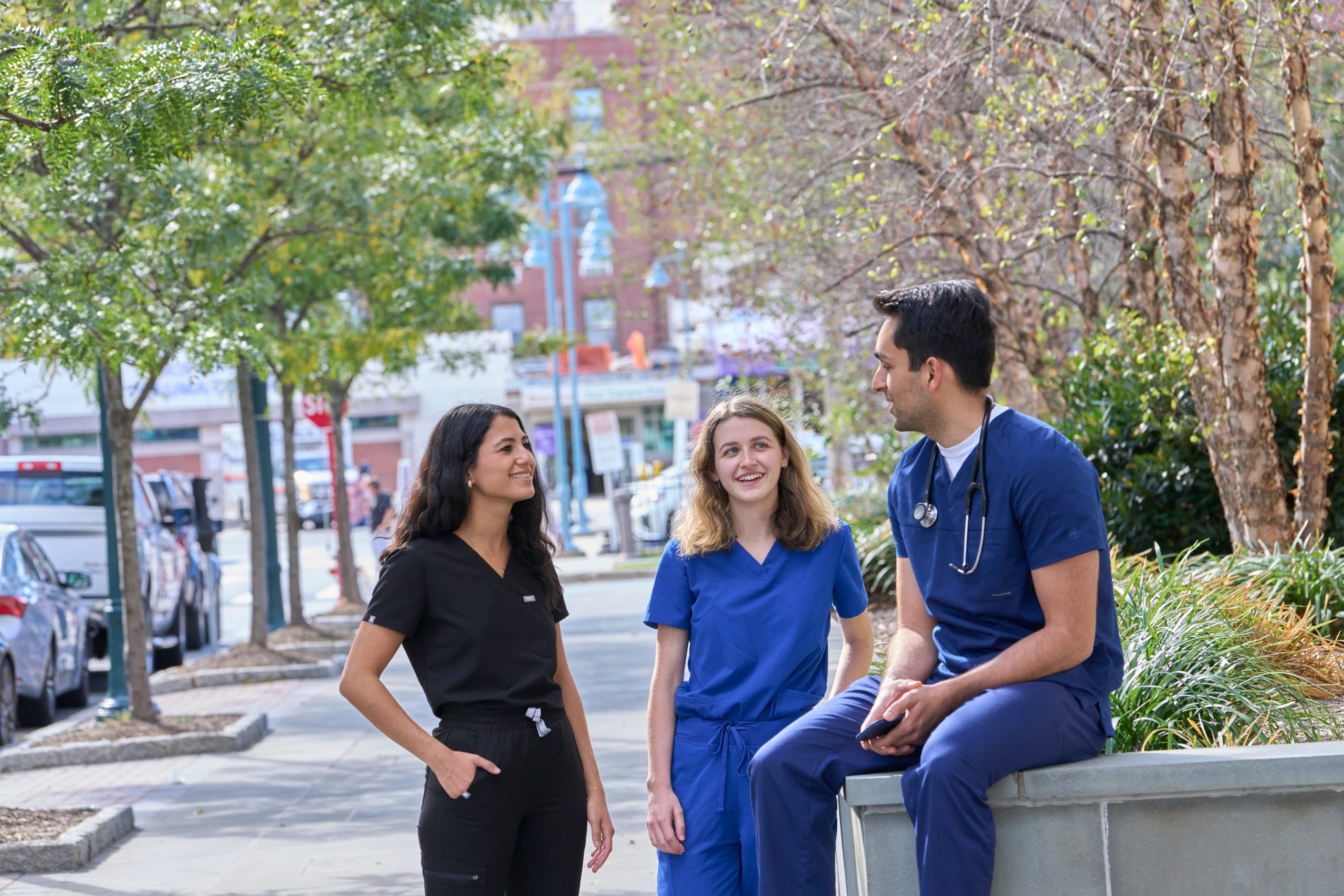 Three NYU Langone staff talk together outdoors.