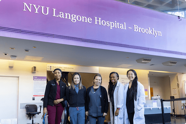 A group of staff members poses in the main reception area of the NYU Langone Hospital—Brooklyn building.
