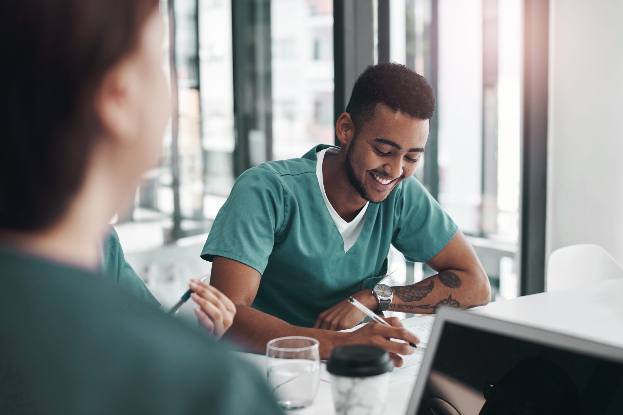 Two NYU Langone Hospital—Suffolk staff members sit and work together.