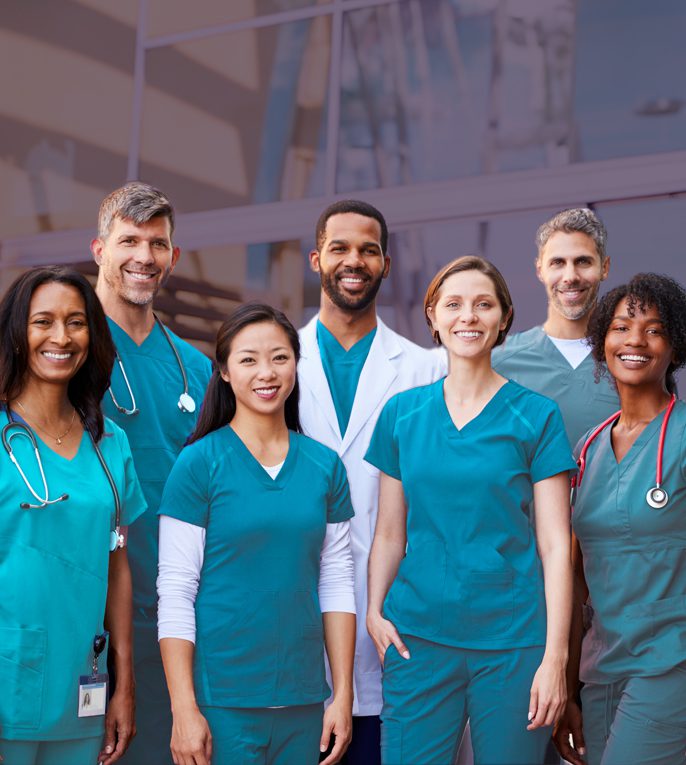A medical team from NYU Langone Health standing in front of a glass building.