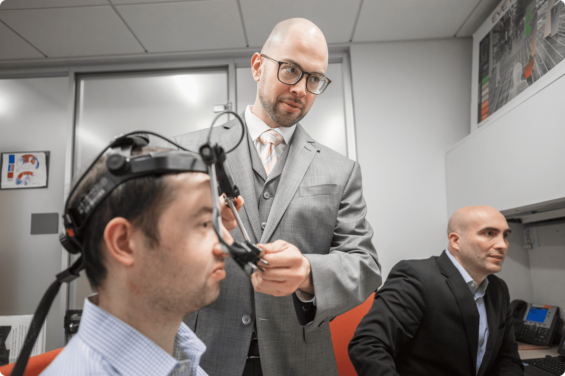 Three male Medical Center Information Technology team members at NYU Langone intently focus on a project they are working on.
