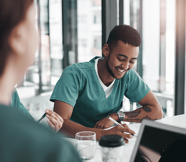 Two NYU Langone Hospital—Suffolk staff members sit and work together.