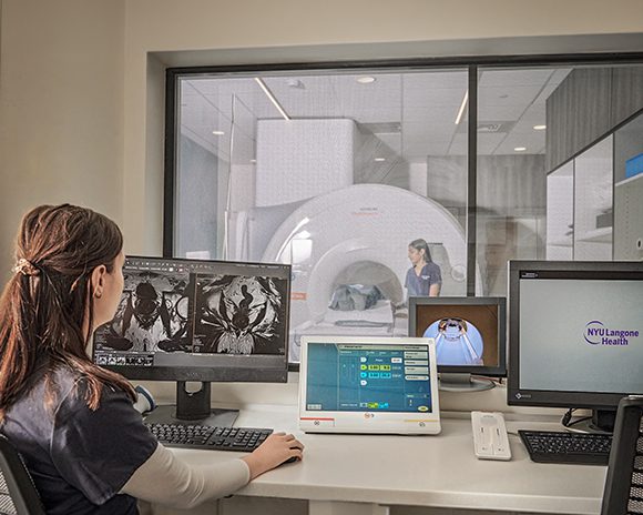 Two technologists at NYU Langone work together to fix a broken machine.